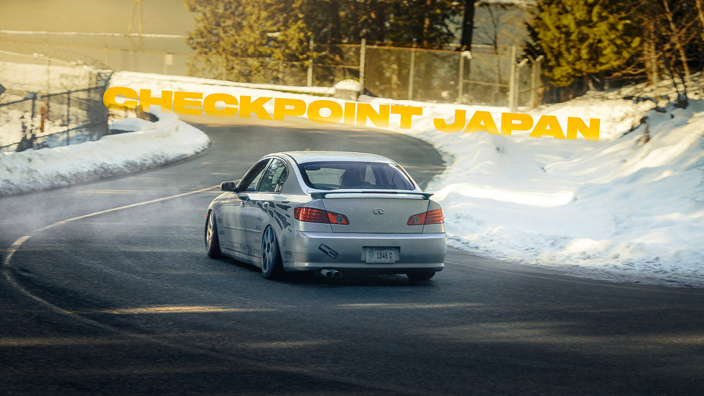 Checkpoint G35 drift car driving down a windy road with snow on either side.