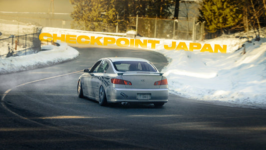 Checkpoint G35 drift car driving down a windy road with snow on either side.
