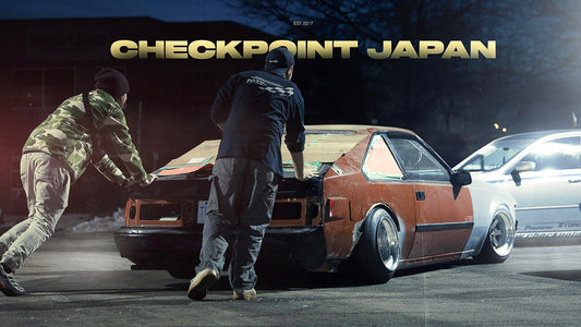 Alex and Jake from Checkpoint push Dylan's kaido racer Toyota Supra MK2 into the shop.