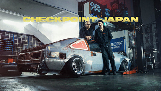 Reid and Sam posed with Dylan's MK2 Toyota Supra taken down to bare metal on a two post lift at the Checkpoint shop.