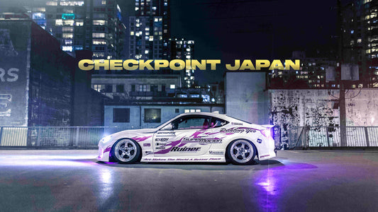 Marcus Lam BRZ with a new livery at night with a lit up city behind it.